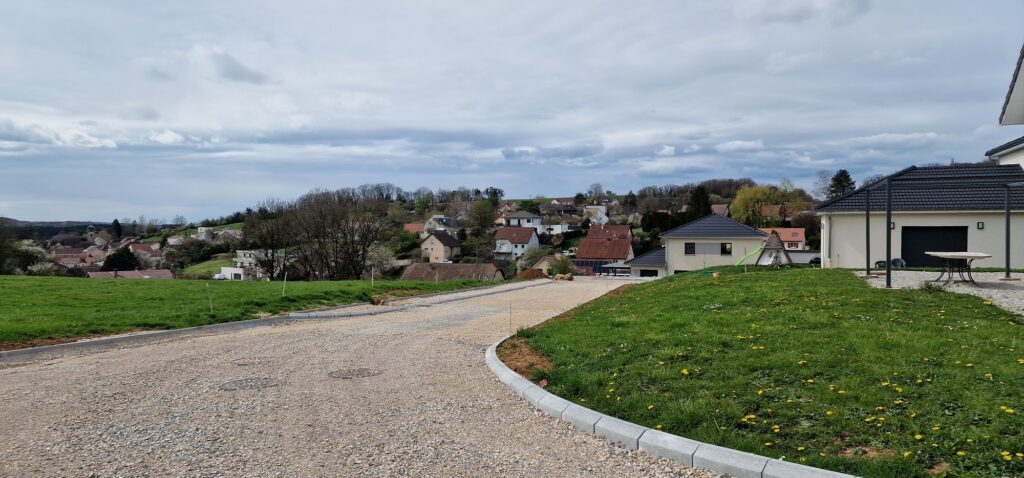 Voirie de lotissement surplombant le. village de Pelousey dans le Doubs avec des maisons individuelles neuves